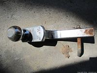 Ball mount with attached ball and separate hitch pin on concrete