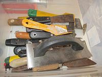 Top view of bin showing assortment of scrapers and trowels