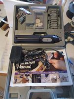 Open case displaying rotary tool, adapter, bits, polishing wheels, manual