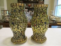 Front view of both mosaic glass candle shades on brass stands
