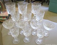 Group of 13 assorted cut crystal stemware glasses on tabletop