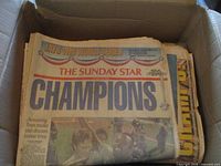 Box of newspapers with Sunday Star "Champions" Blue Jays World Series headline on top