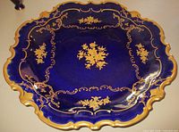 Top view of cobalt blue Reichenbach dish with gold decoration and scalloped rim