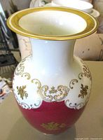 Overall view of porcelain vase showing ruby red lower body, white neck, gold gilt decoration and rim
