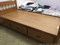 Wooden single captain's bed with headboard and 3 drawers underneath, drawer handle partially damaged.