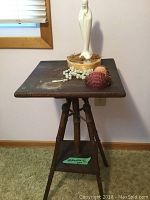 Side table showing full piece with items displayed on top and wooden window frame in background