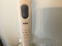 Close-up photo of Braun hand mixer showing brand, power and control button