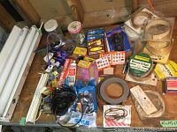 Overview of lot showing fluorescent tubes, tapes, screen repair kit, staple gun staples, and other assorted hardware items.