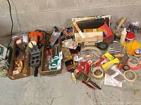 Full overview of lot showing jig saw, painting supplies, brushes, tapes, and woodworking items on floor