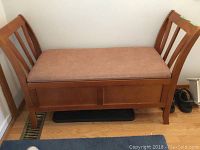 Front view of wooden bench with micro suede seat and slatted armrests.