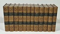 Spines of all 12 matching leather-bound volumes showing gilt tooling and title labels