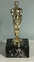 Full view of gold-tone statuette on marble base
