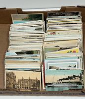 Open cardboard box filled with hundreds of postcards