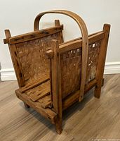 angled side view of woven wood basket showing handle and base