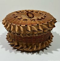 Three-quarter view of basket showing lid, curled trim and overall form