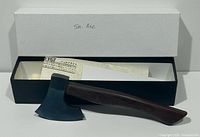 Hatchet resting in open presentation box with paperwork visible
