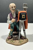 Front view of figurine showing photographer, camera, colours and details