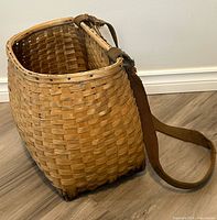Angled view showing woven wood construction, one canvas strap visible