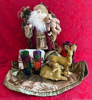Group shot of Santa, deer, tree skirt, four glass candle holders, ornament