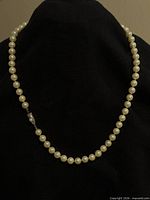Full view of imitation pearl necklace on display bust
