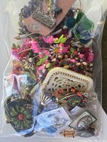 Sealed bag displaying variety of colorful beaded costume jewelry and brooches