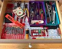 Drawer view showing most screwdrivers, precision sets, levels, mounting tape and lighter