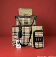 Three Burberry Nova Check items with two dust bags displayed