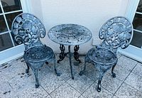 Full view of cast iron bistro set: table and two chairs
