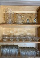 Cabinet view of entire lot showing pitcher, vase, martini glasses, coupes, tumblers, rocks glasses
