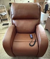 Front view of brown power lift recliner with remote on seat