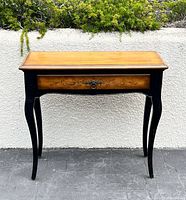 Front view of console table showing full form, honey top, black base, cabriole legs