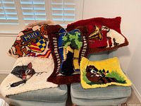 Group shot of all five latch-hook rugs draped over chairs
