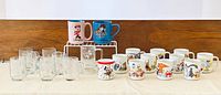All 21 mugs arranged on table showing ceramic and glass pieces