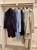Five coats and liner hanging on rack, full lot view