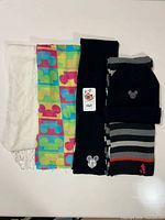 Five accessories: white scarf, multicolor scarf, black knit scarf, black beanie, striped knit scarf