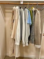 Full rack view of nine garments on hangers