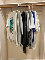 Eight Disney Marathon tops hanging on closet rod