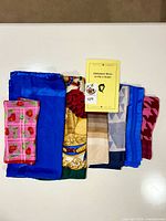 Stack of folded scarves and booklet showing variety, colours, patterns
