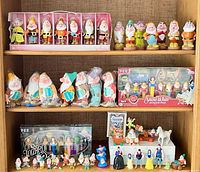 Full shelving view showing all figurines, plush dwarfs, PEZ sets