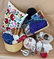 Group shot of entire assortment in basket with pillow, bowl, utensils, linens and ceramics