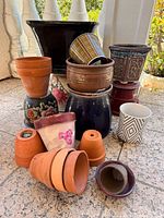 Group shot showing all assorted terracotta and glazed ceramic flower pots stacked and clustered