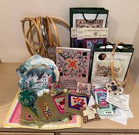 Overall view of hoops, kits, finished pieces, pin cushion and pattern booklets