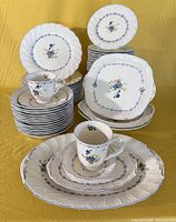 Overall lot showing multiple stacks of plates, bowls, cups and serving pieces