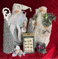 Full lot showing two Santas, two glitter cone trees, jingle bells package, floral picks
