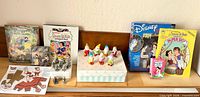 Overall lot showing figurines, books, puzzle, paper dolls