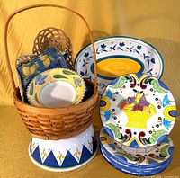 Group shot showing plates, platter, wicker basket with linens and ceramic stand