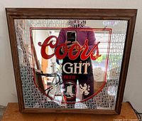 Front view of 1989 Coors Light mirrored illuminated sign, showing shield graphic and wood frame
