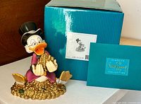 Front view of Scrooge McDuck figurine with box and certificate visible