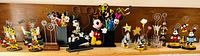 Shelf view of all Disney desk accessories including pencil holder, stapler, multiple photo holders and figurines