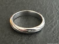 Twisted gold band ring profile view on dark background